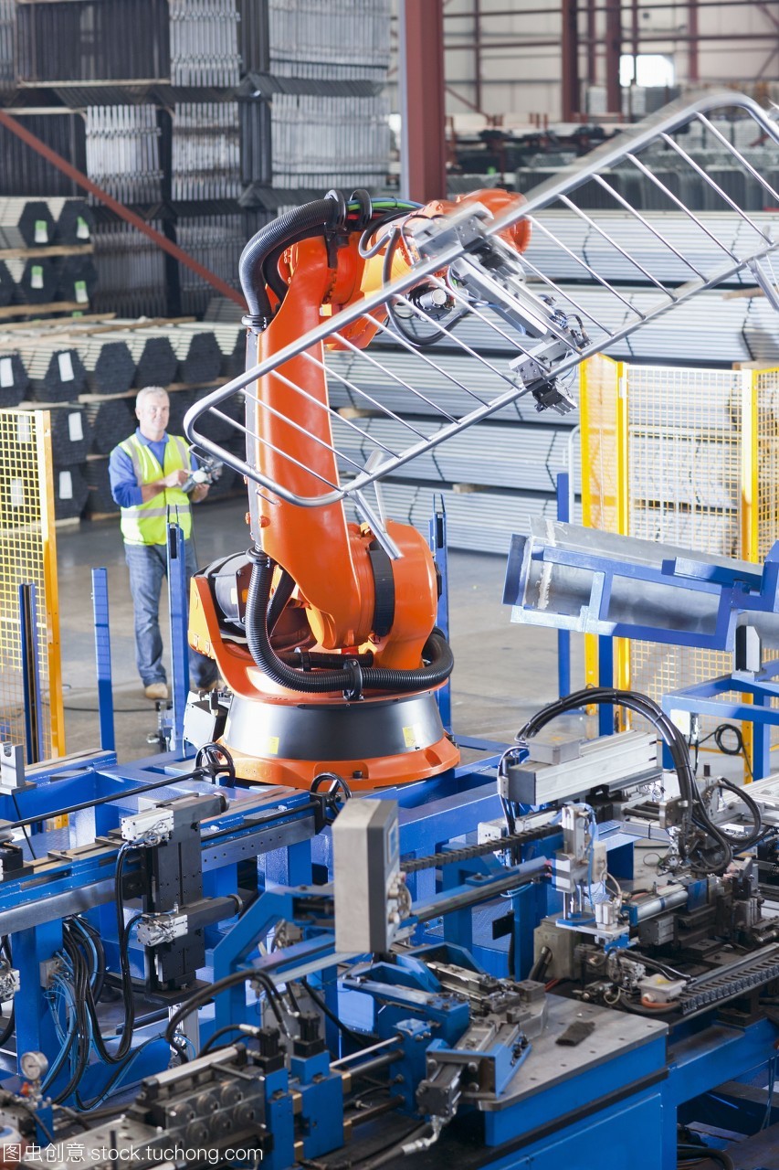 工人在制造工厂的生产线上控制机械吊装